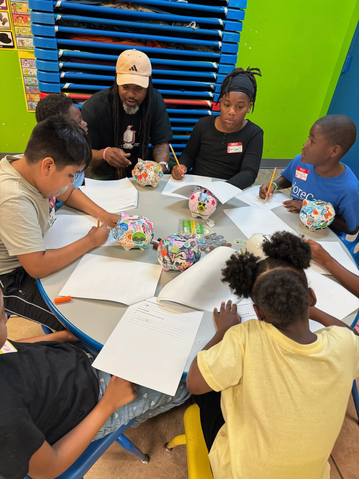 Children work on savings goal worksheets with a mentor